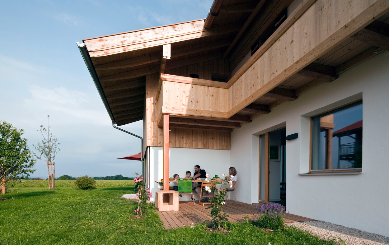 Eine Familie genießt den Nachmittag auf der Terrasse eines modernen Passivhauses in Chieming.