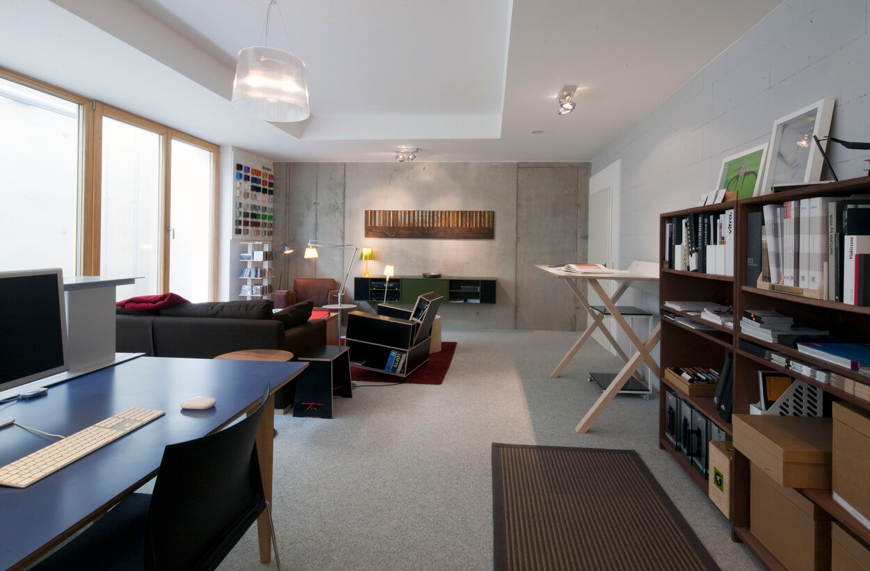 Ein modernes Wohnzimmer in einem Passivhaus in Chieming mit stilvollen Möbeln und großen Fenstern für viel Tageslicht.