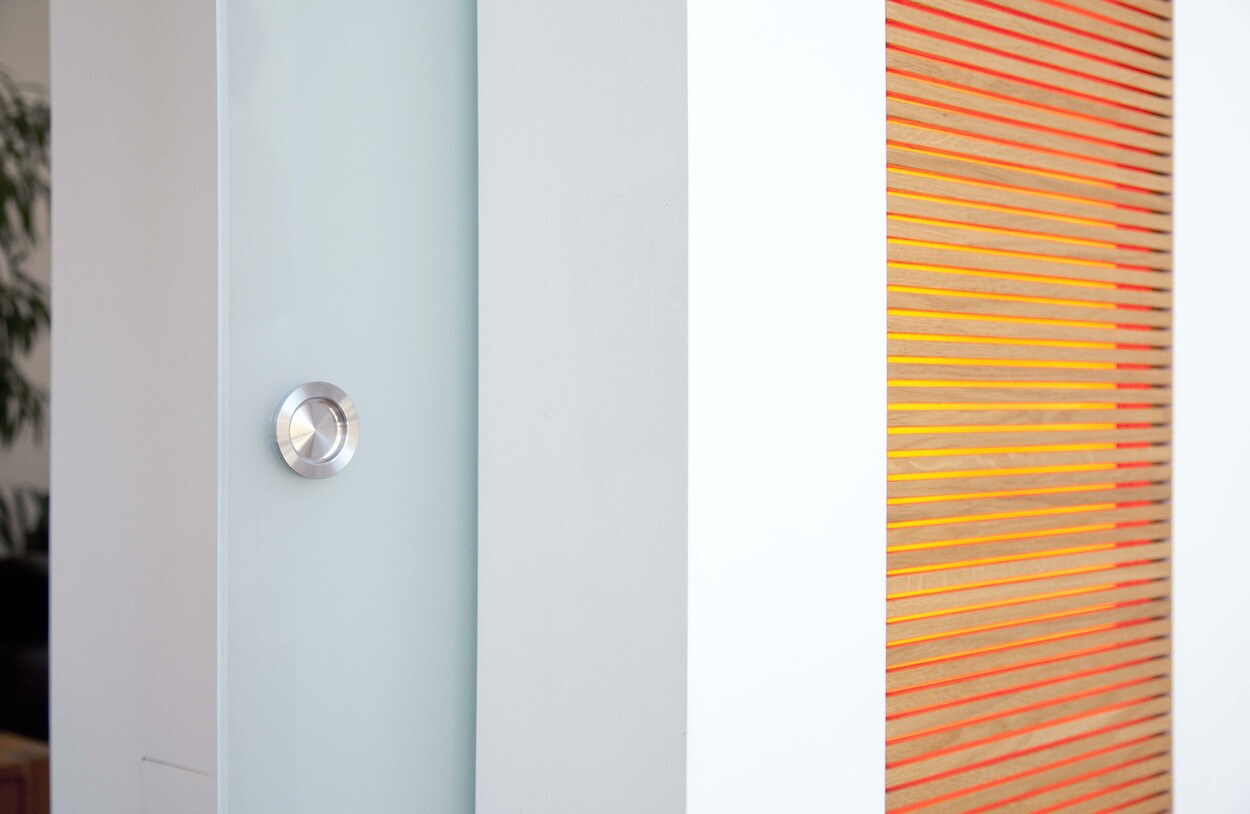 Eine moderne Wand im Passivhaus-Stil in Bad Aibling mit orangefarbenen Linien und minimalistischen Designelementen.
