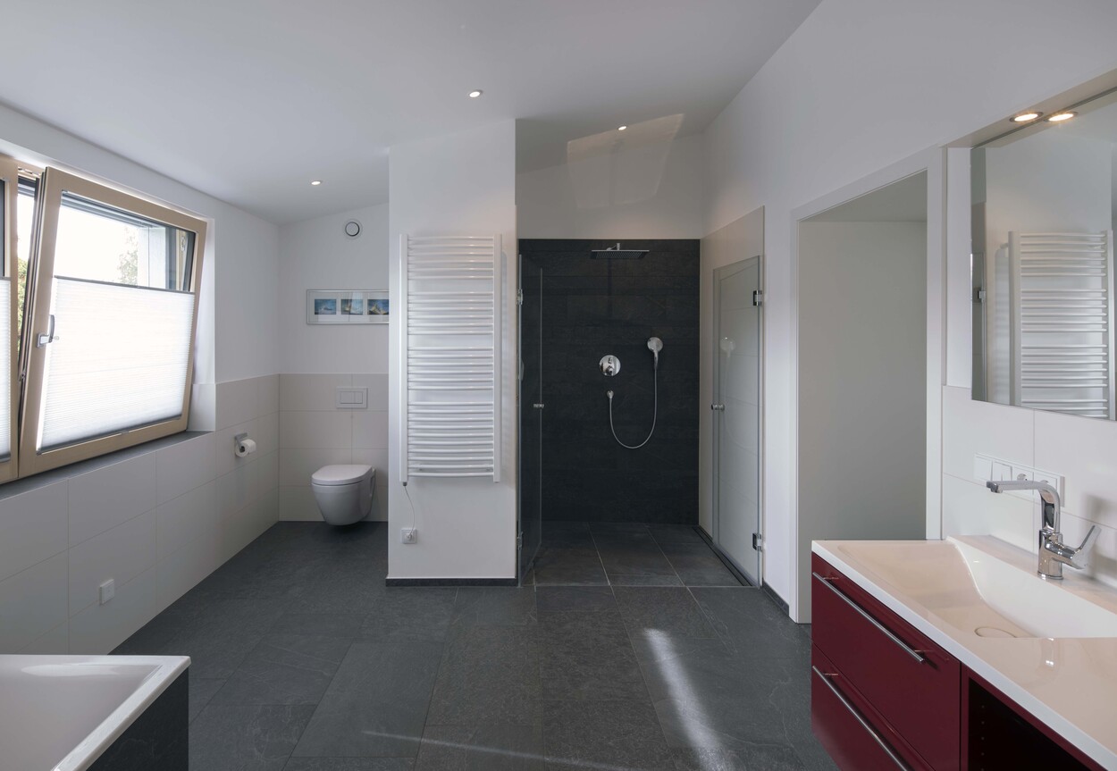 Modernes Badezimmer in München mit offener Dusche, großem Fenster und eleganter Waschtischarmatur.