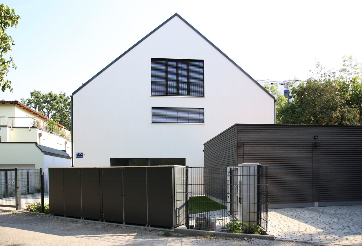 Ein modernes Passivhaus-Doppelhaus in München besticht durch schlichtes Design und gepflegte Außenanlage.