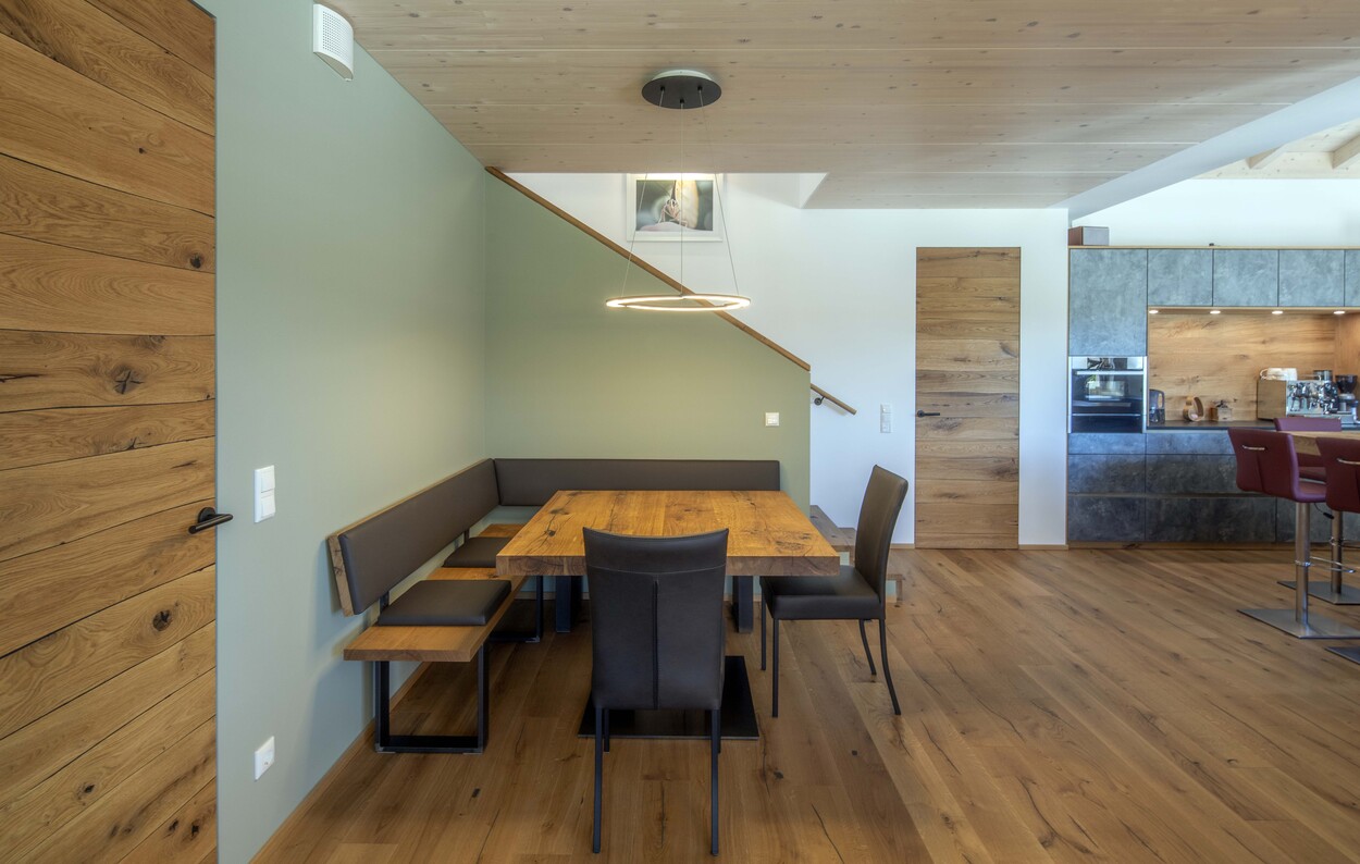 Ein modernes Esszimmer in Prien mit Holztisch, Eckbank und stilvoller Beleuchtung lädt zum Verweilen ein.