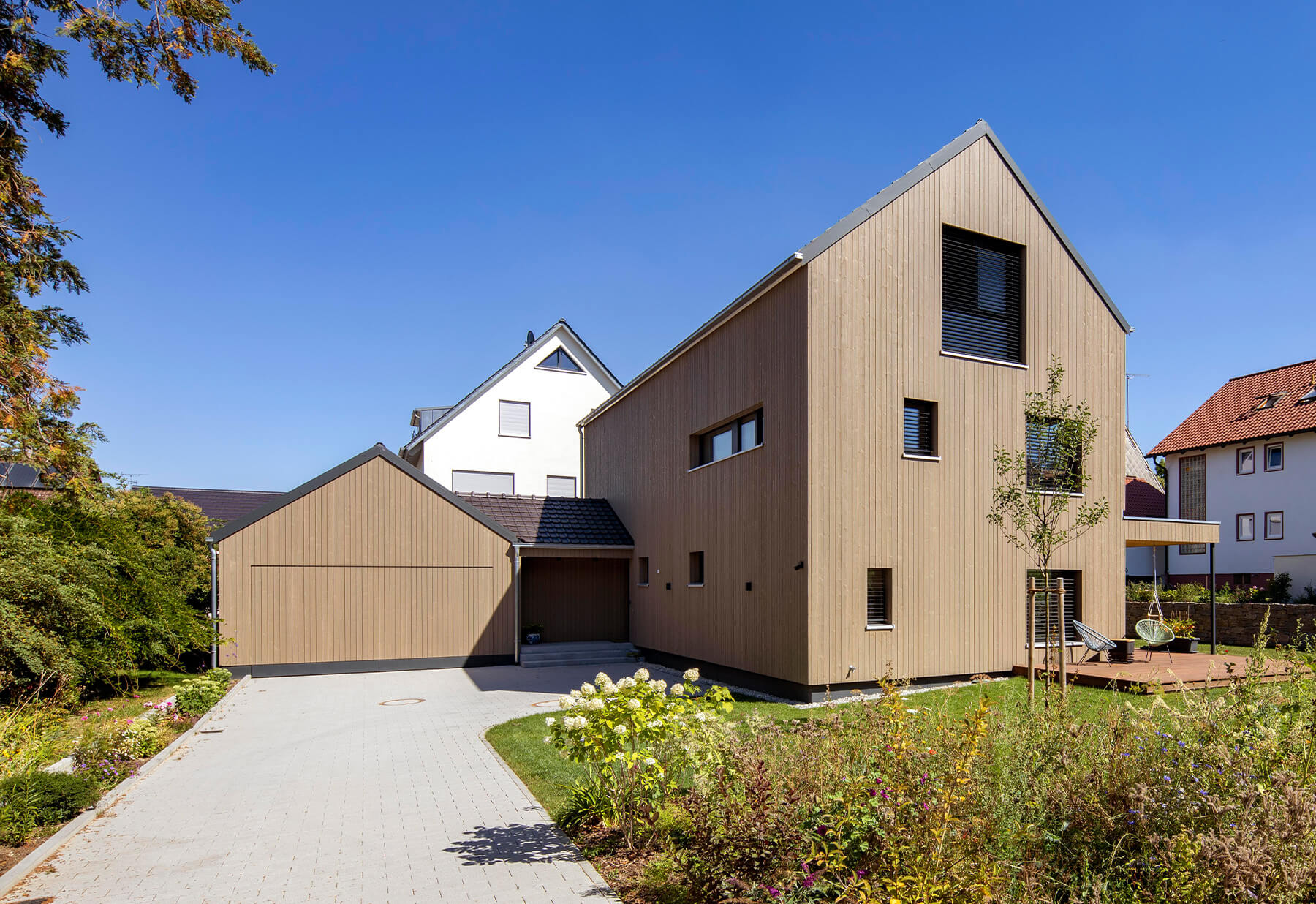 Mehrfamiliehaus, Holzfassade mit Carport
