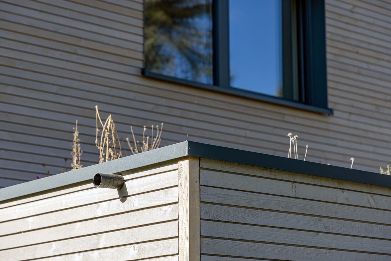 Holzhaus mit Holzfassade und begrüntem Carport