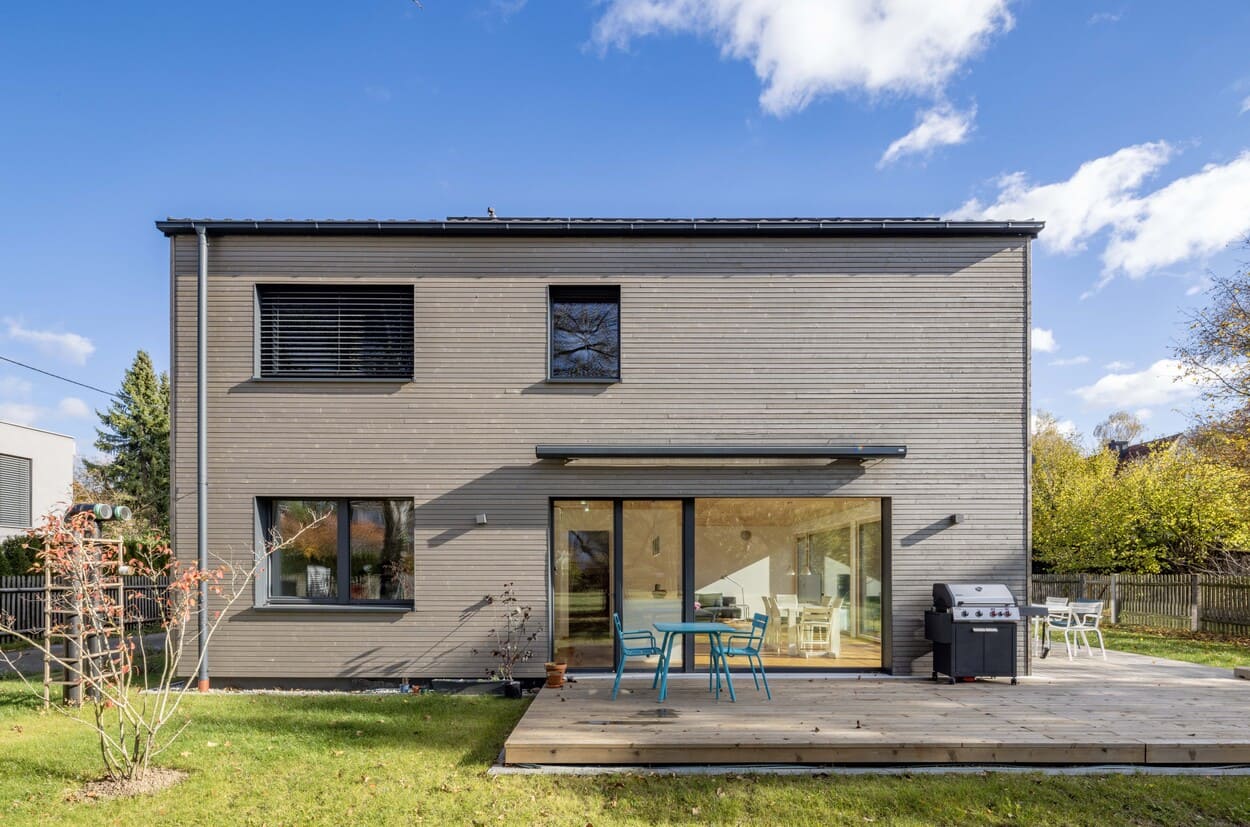 Ostseite von Holzhaus in Obermenzing bei München, Graten und Holzterrasse, bodentiefe Fenster