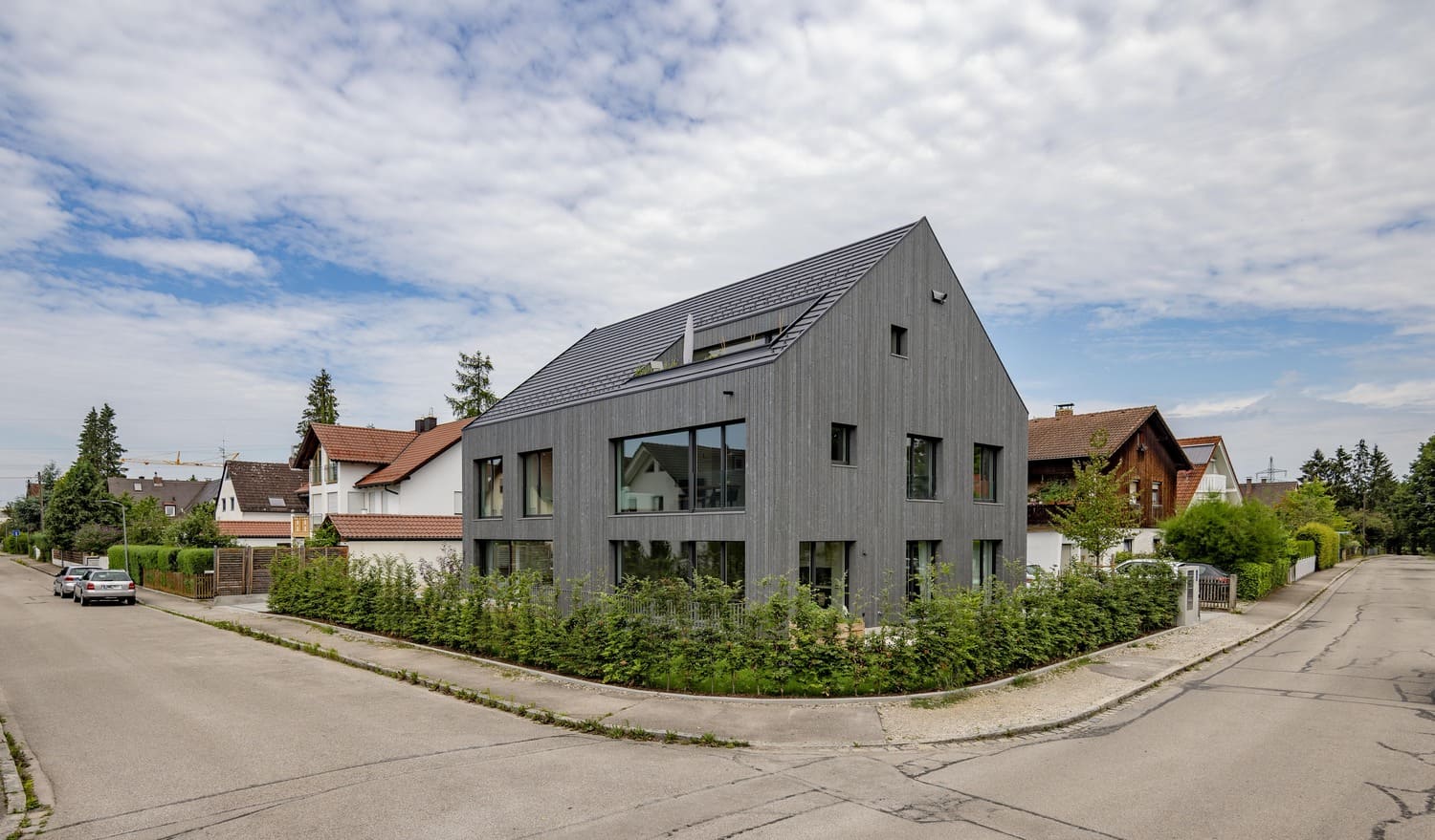 Modernes Mehrfamilienhaus in Aubing mit grauer Holzfassade, ohne Dachüberstand