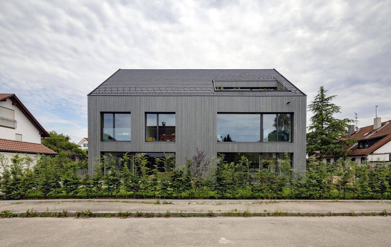 Modernes Mehrfamilienhaus in Aubing mit bodentiefen Fenstern, graue Holzfassade, Dachterrasse
