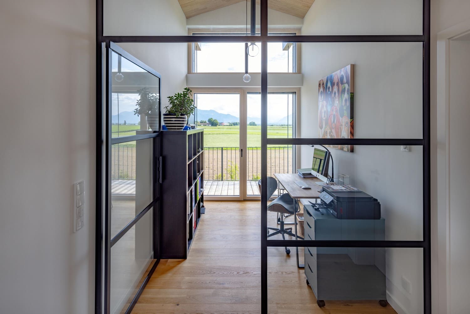 Flur im OG mit Blick auf Glas-Loft-Element mit schwarzem Rahmen, Treppe mit schwarzen Handlauf, Blickrichtung Süden