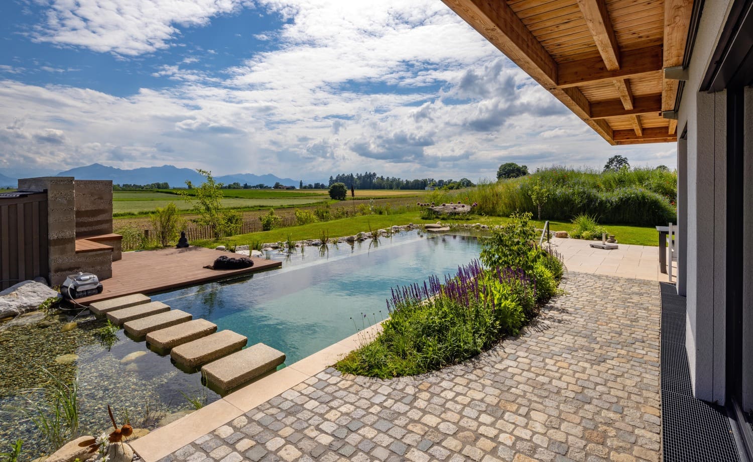 Natur-Schwimmteich mit Trittplatten und Sitzecke