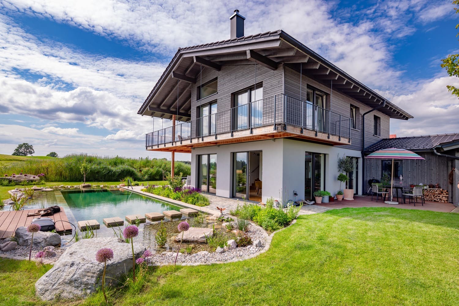 Südostansicht Holzhaus Chieming, Putz- und Holzfassade mit Schwimmteich natur