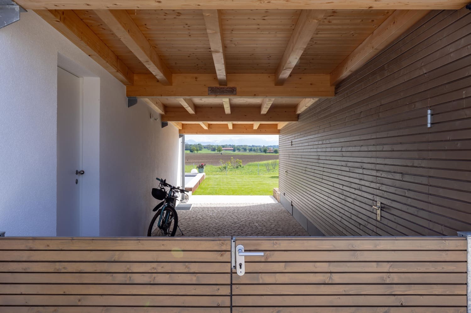 Holzhaus verputzt in Weilheim, Durchgang von Straße in Garten überdacht, Holzeingangstor