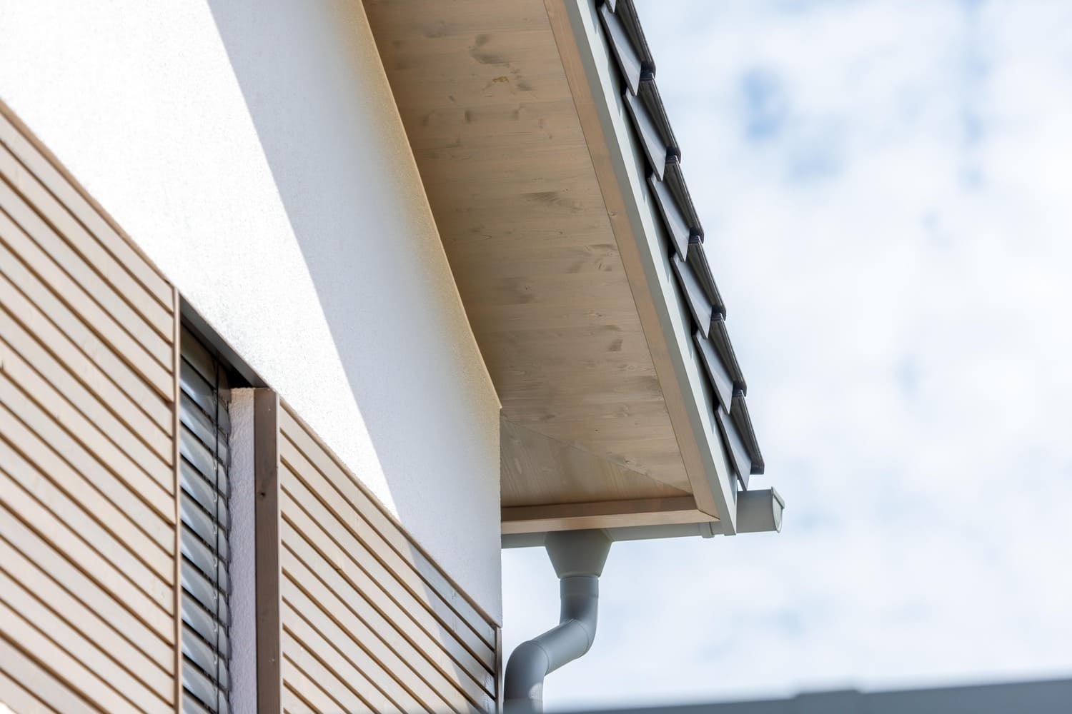 verputztes Holzhaus in Weilheim mit Holzfassadenelementen auf der Putzfassade im OG