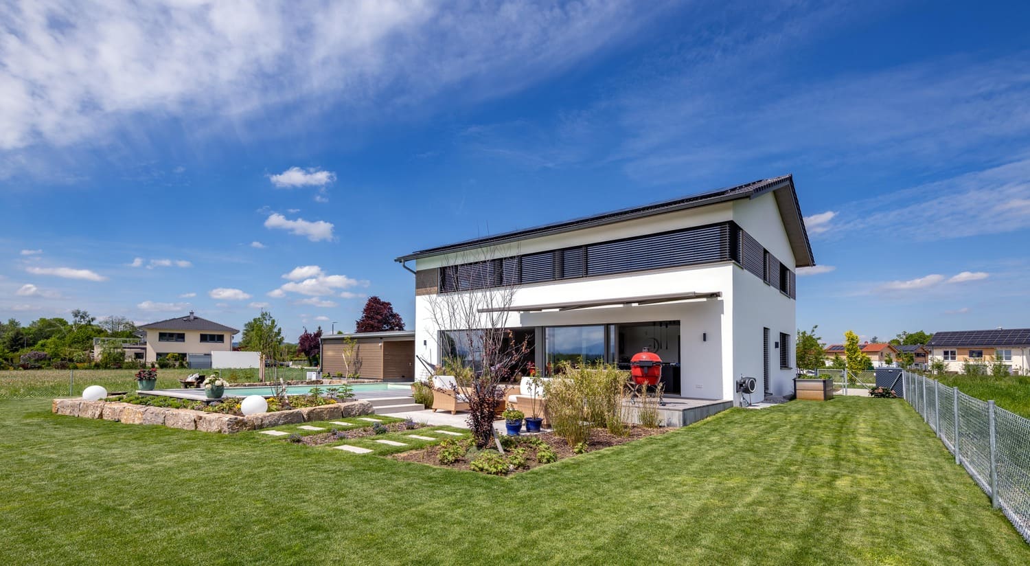 Garten und Pool mit verputztem Holzhaus