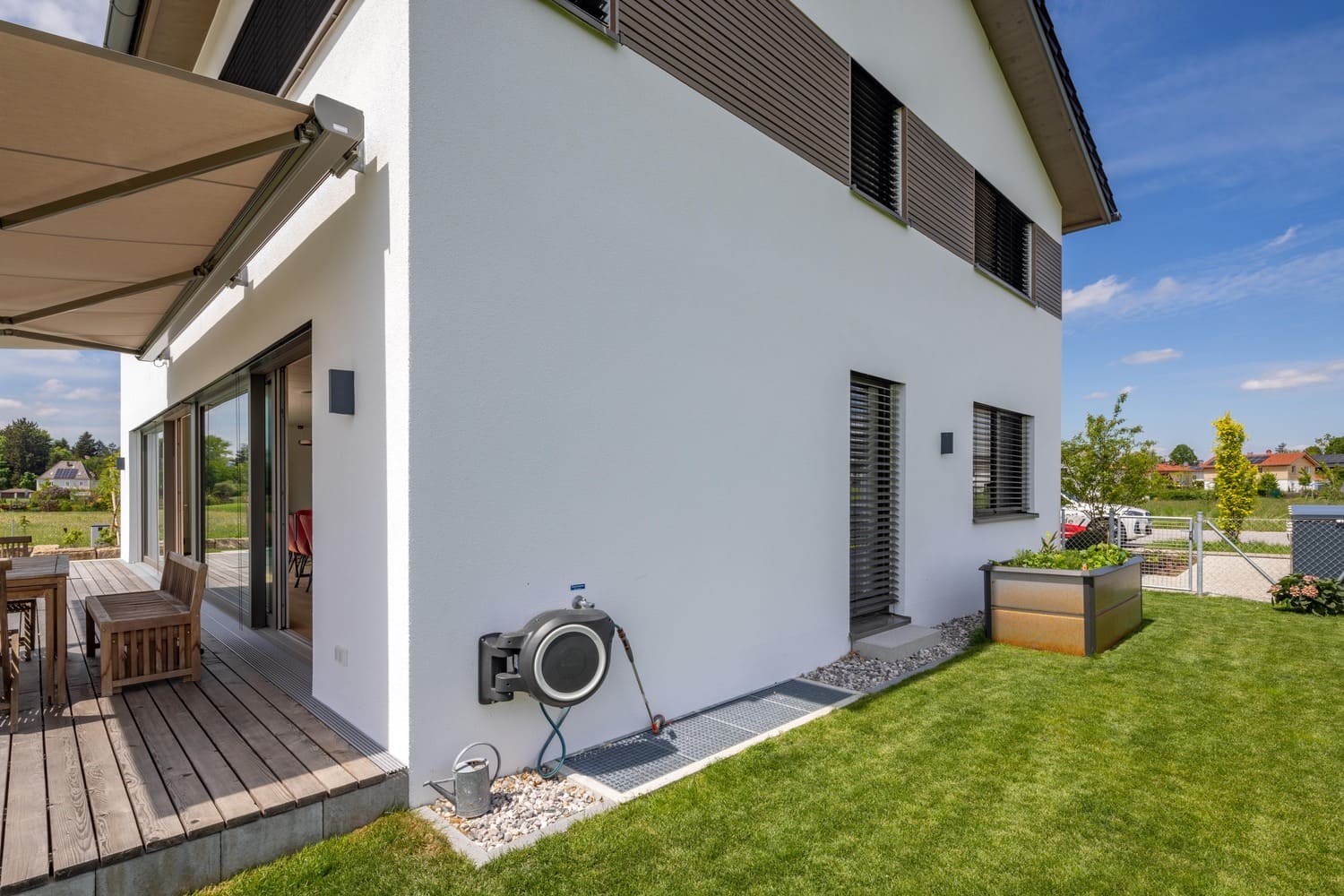 verputztes Holzhaus in Weilheim mit Holzfassadenelemente zwischen den Fenstern