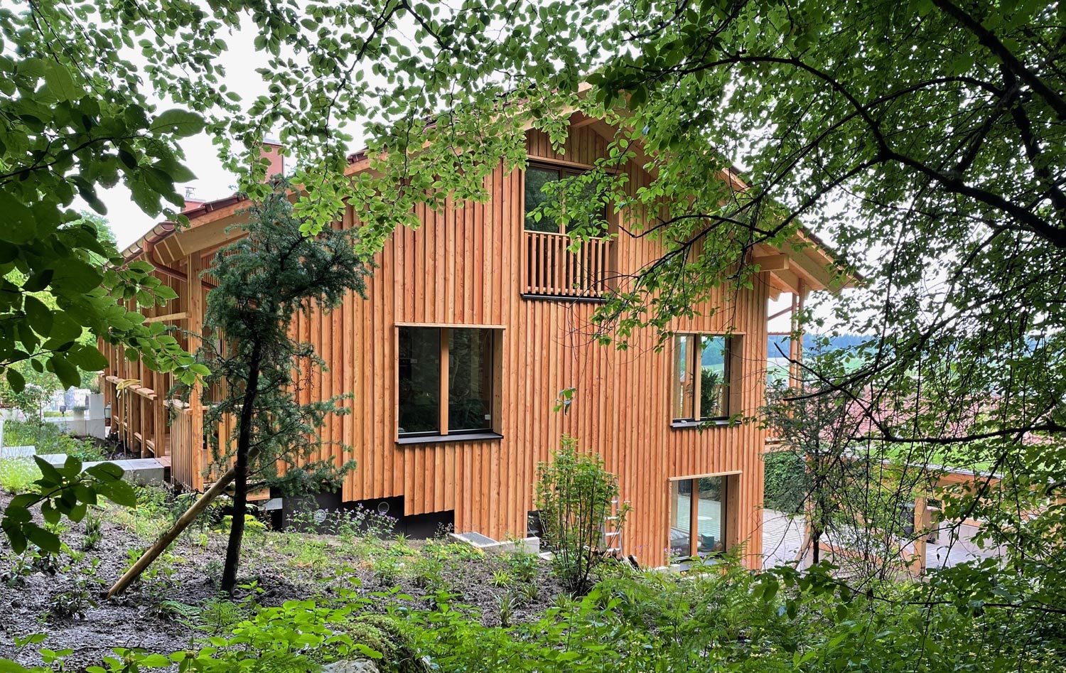 Holzhaus Miesbach, Mehrfamilienhaus am Hang, Rückseite, Holzfassade