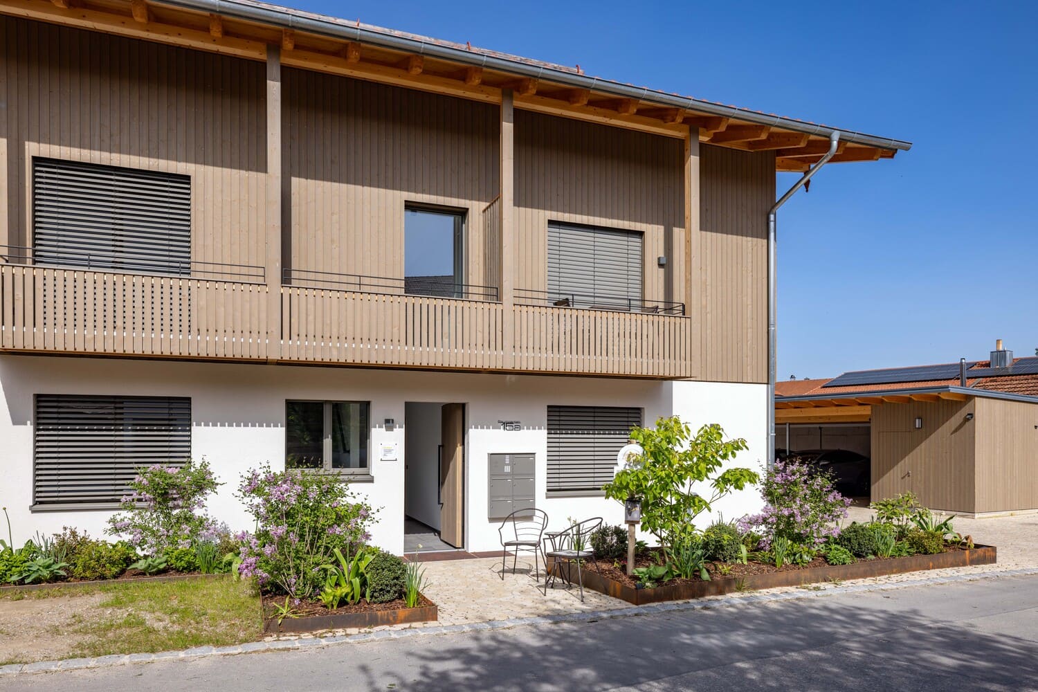 Mehrfamilien Holzhaus in Übersee, Holz- und Putzfassade , Eingangsbereich außen