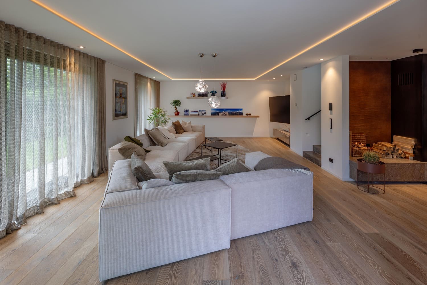 Helles Wohnzimmer mit modernem Sofa, Pflanzen und Kamin, perfekt für Entspannung und geselliges Beisammensein.